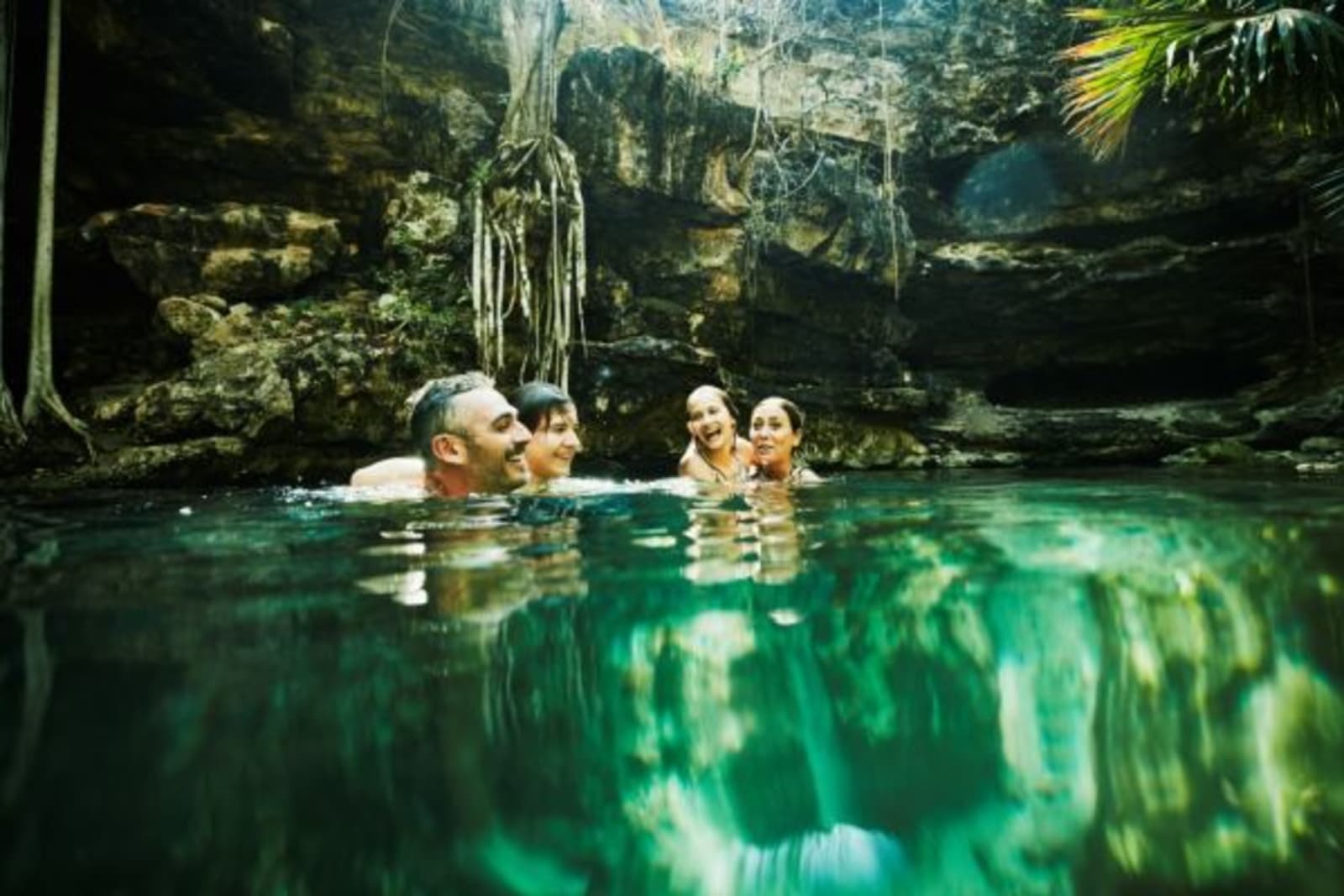 Family swimming in a cenote in the Riviera Maya