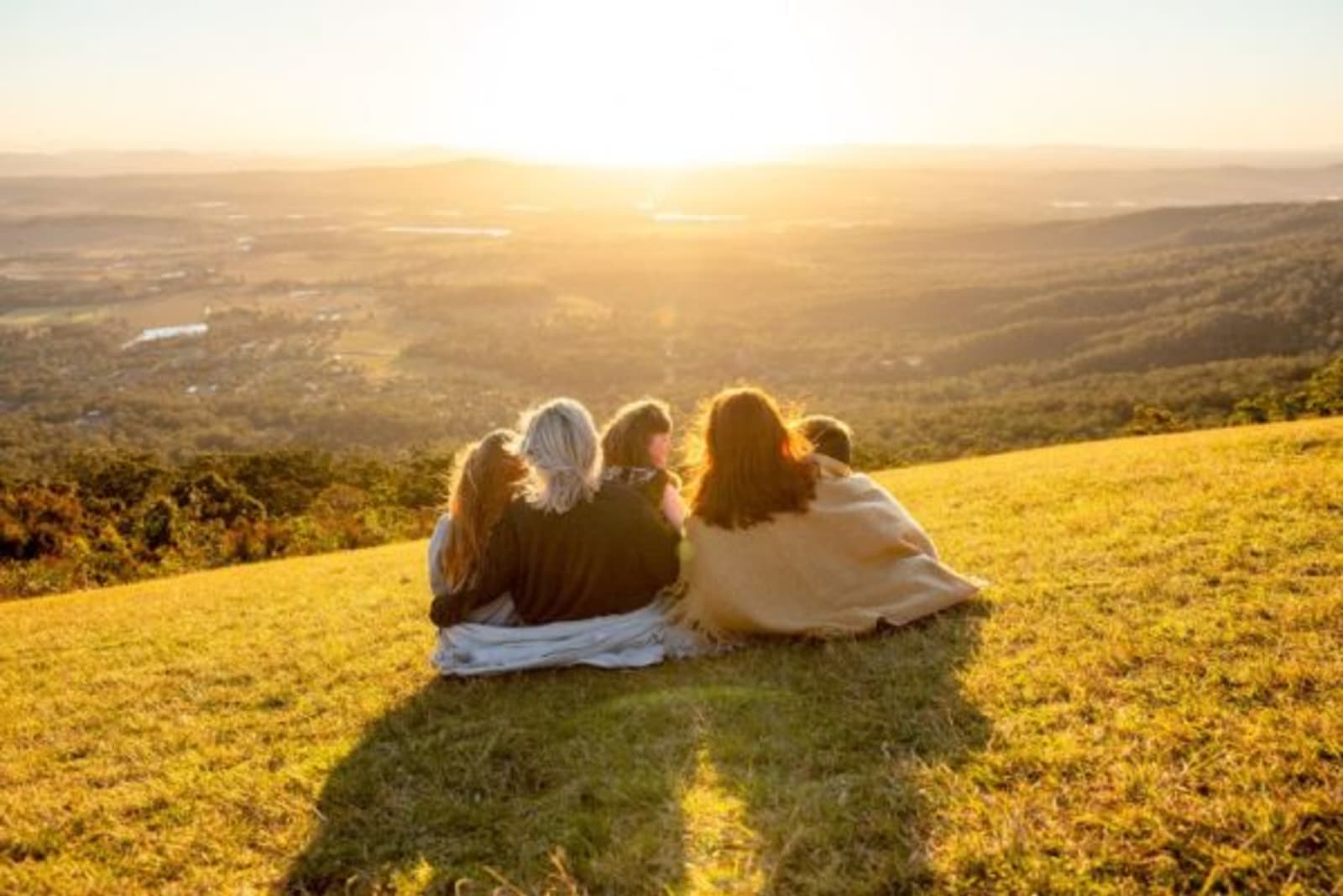 Group of people sitting on Tamborine Mountain lookout watching the sun set