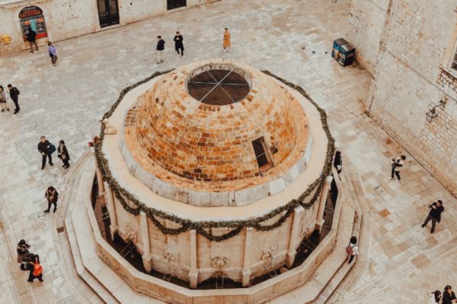 Birds eye view of a circular old building with people walking past