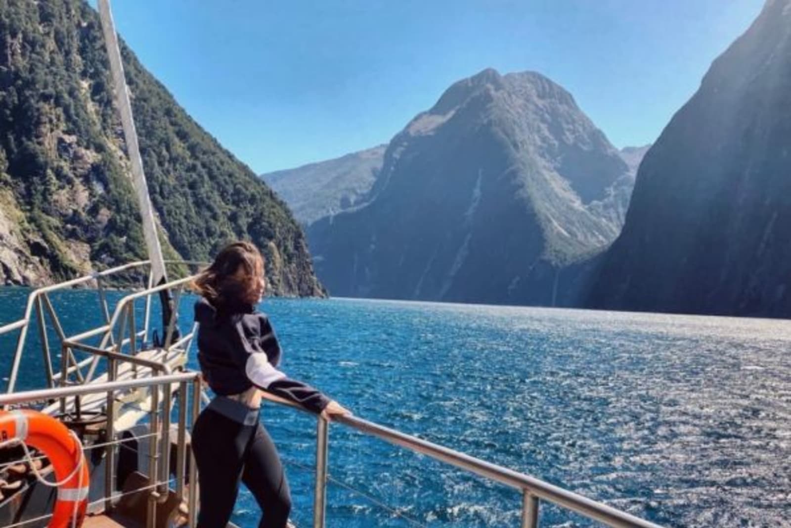 Female leaning on boat railings in Milford Sound