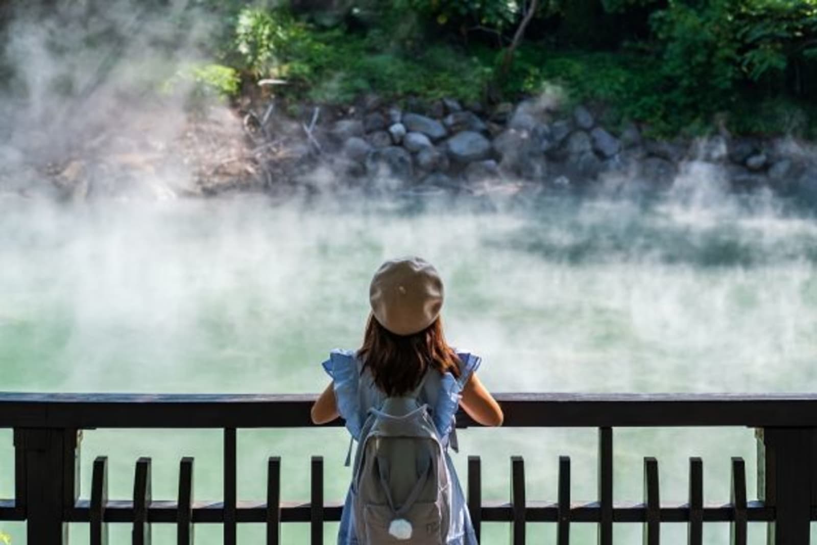 Female looking at steam coming from water (hot springs)