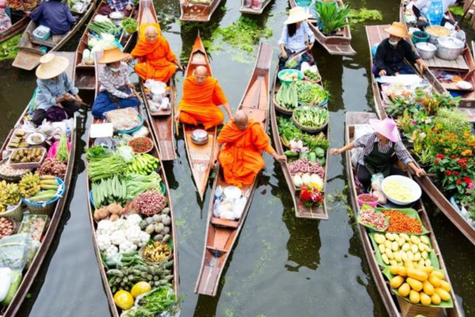 Canoe's carrying variety of fresh foods with monks in orange sit in separate canoe's
