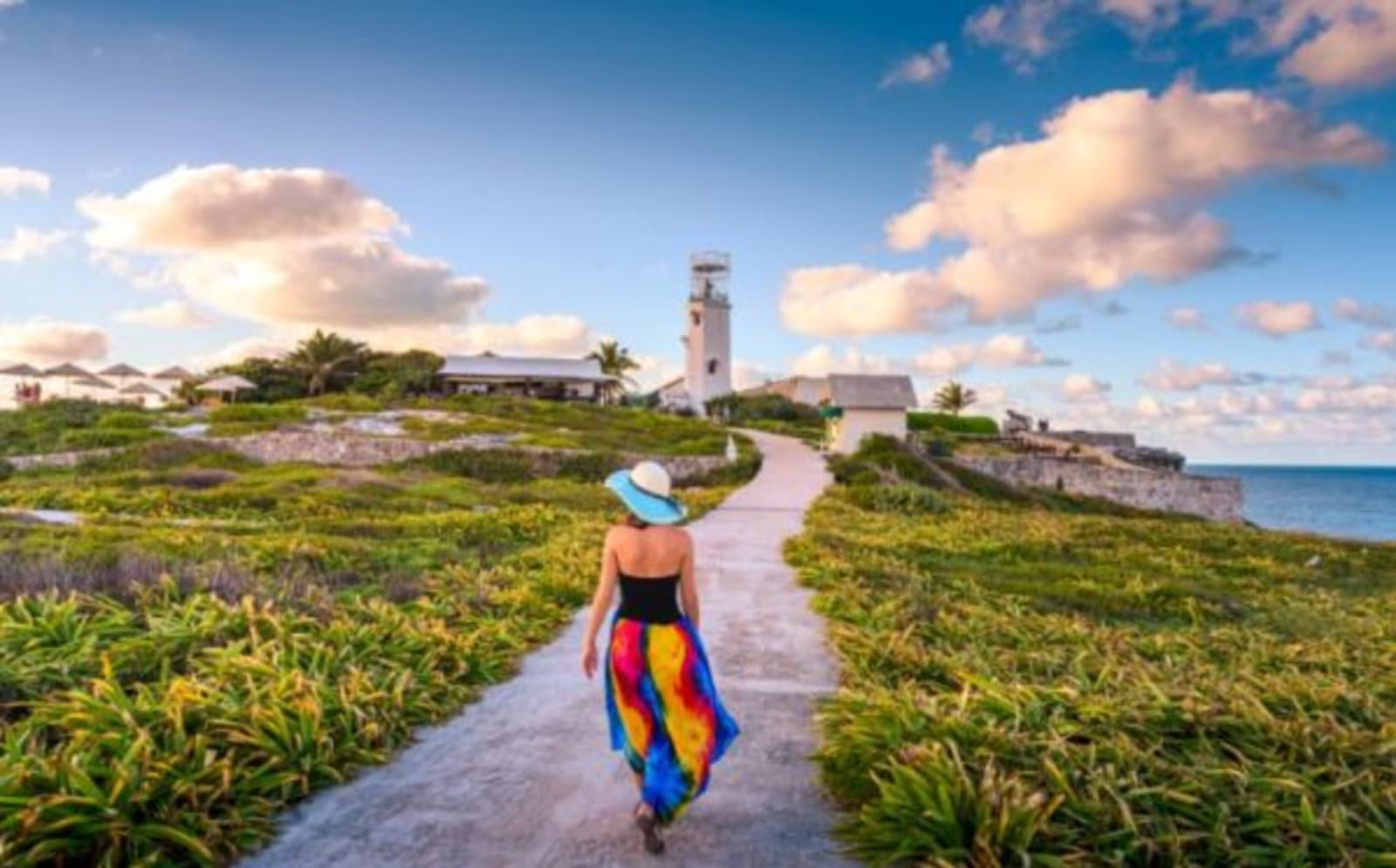 woman walking on coastal path with bright skirt
