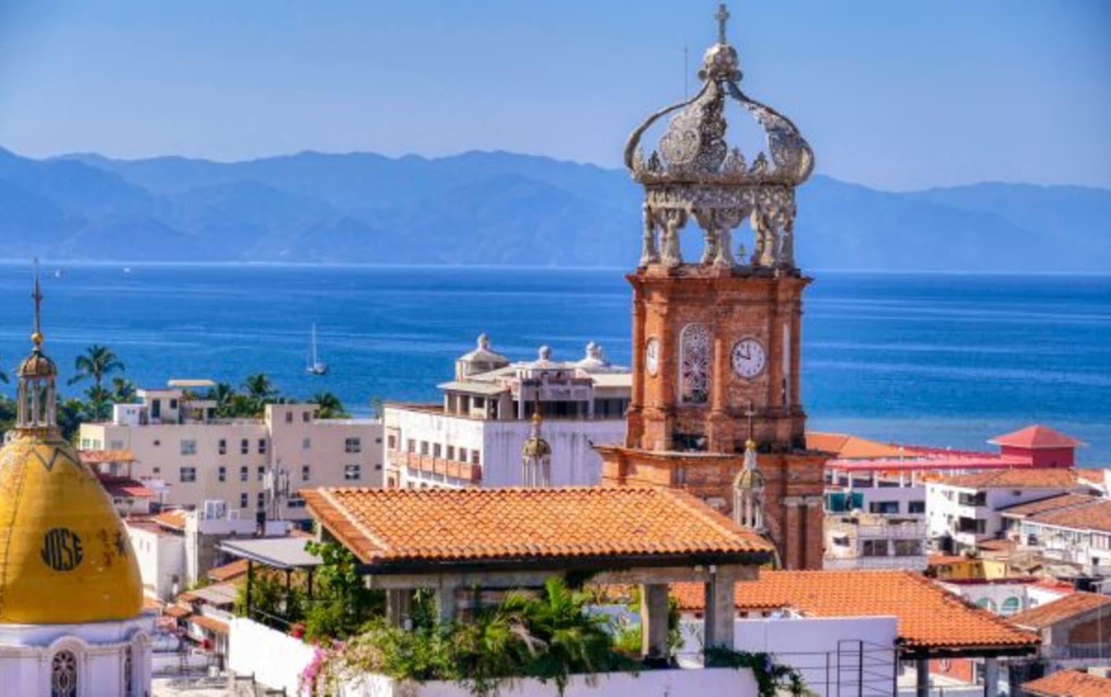 Town of Puerto Vallarta with town clock as focal point and ocean/mountains in background