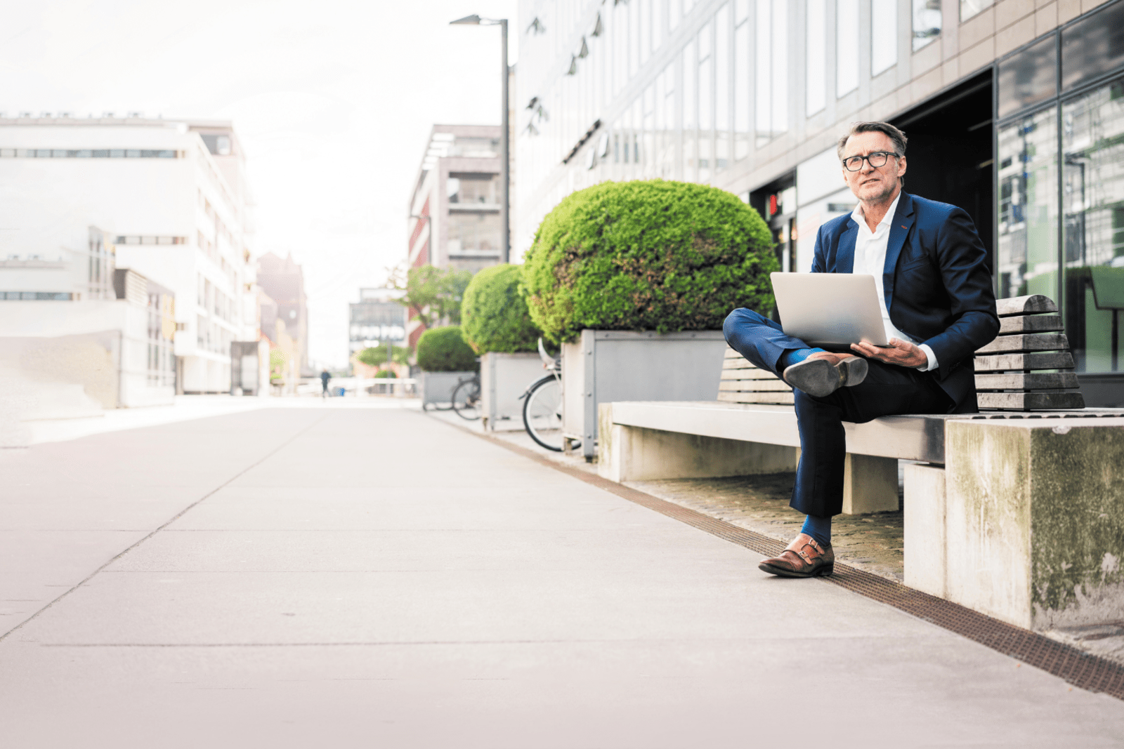 Gentleman sitting outside airport on laptop