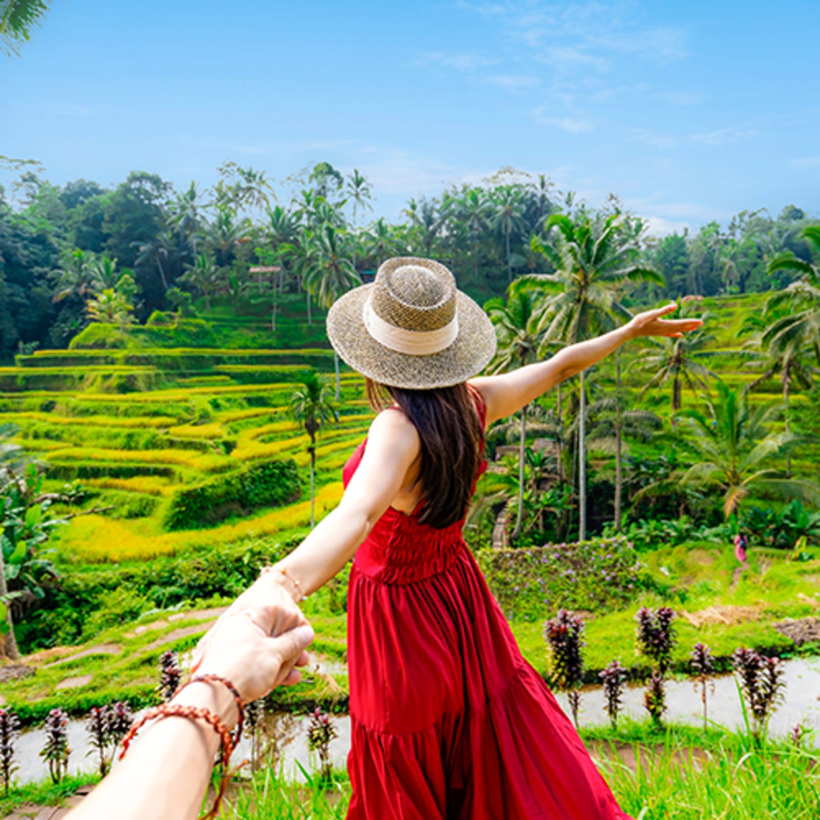Woman in red dress looking out at Rice fields in Bali
