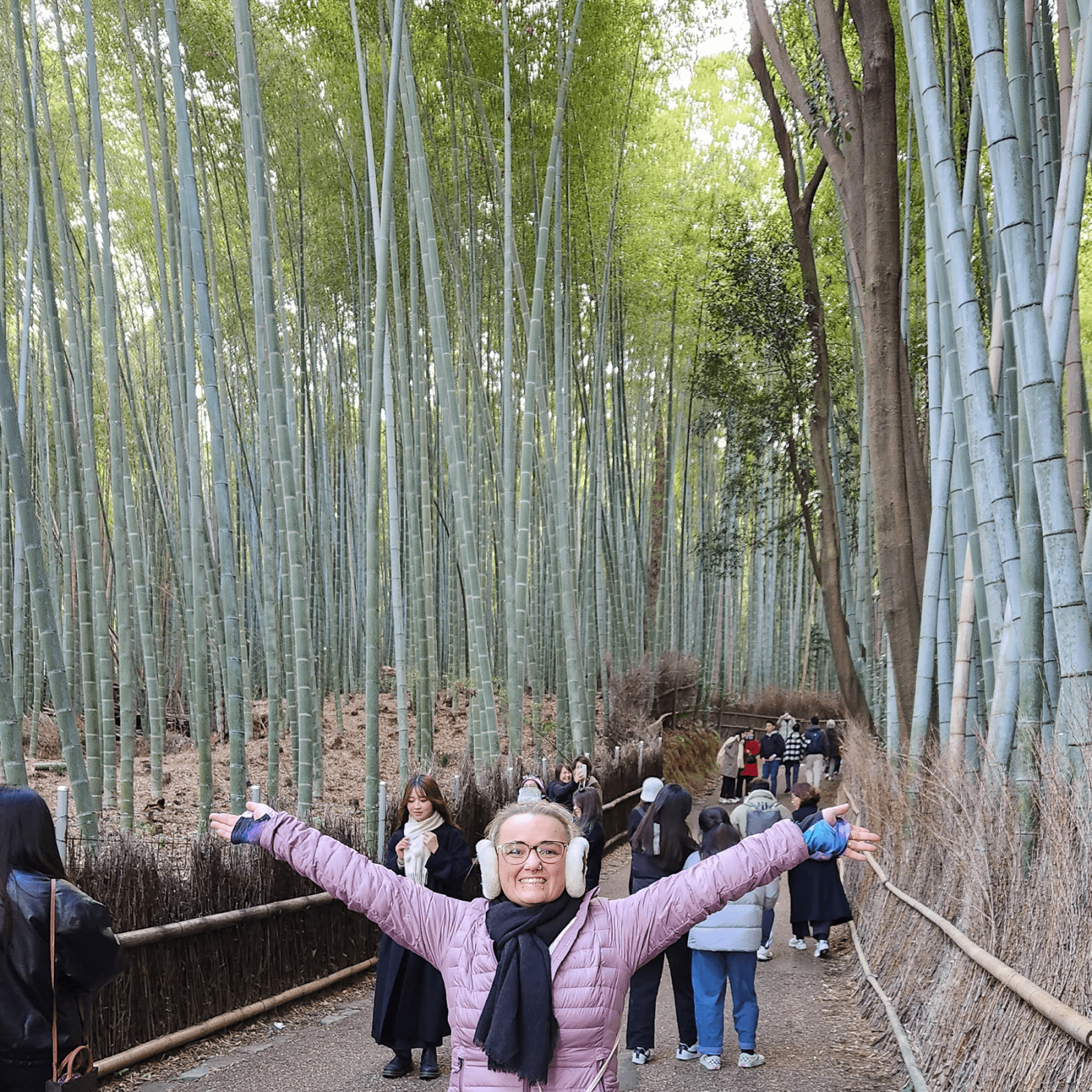 Smiling woman posing in Arashiyama Bamboo forest in Kyoto, Japan