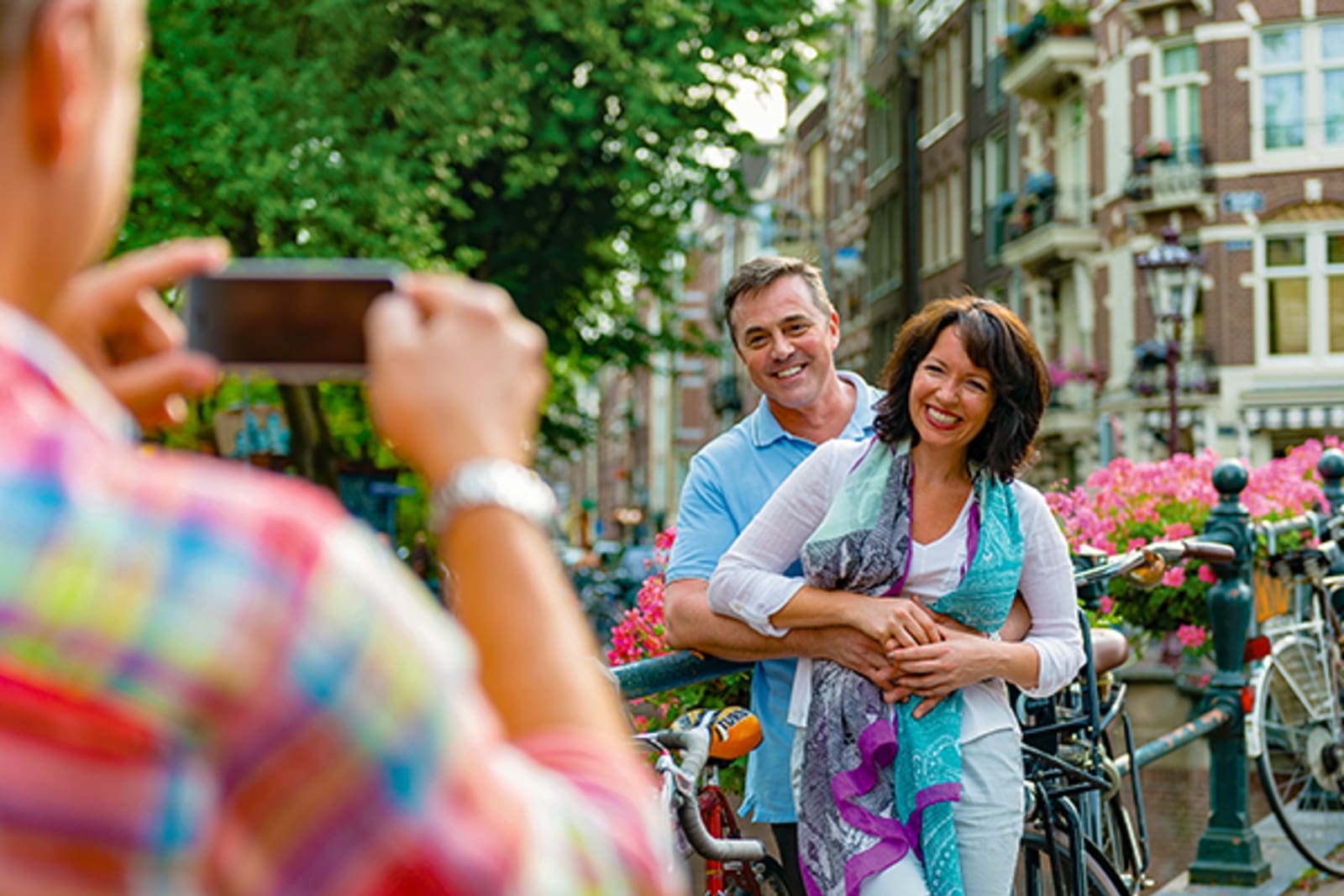 Couple posing for a photo in front of bikes and old European buildings