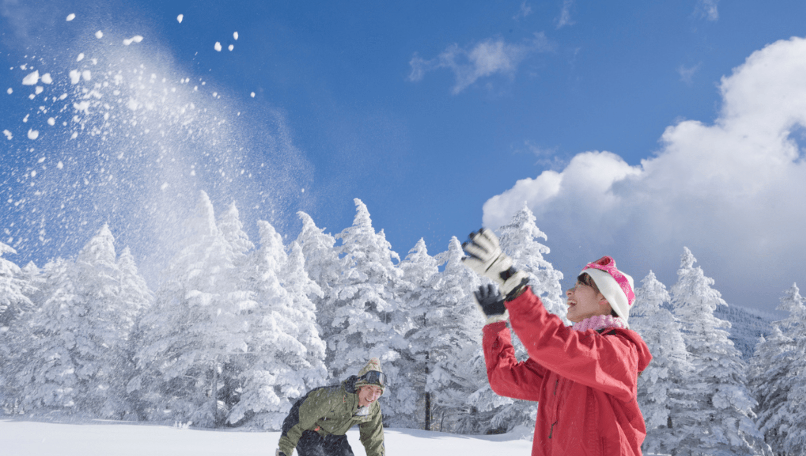 Two people throwing snow up into the air in Japan