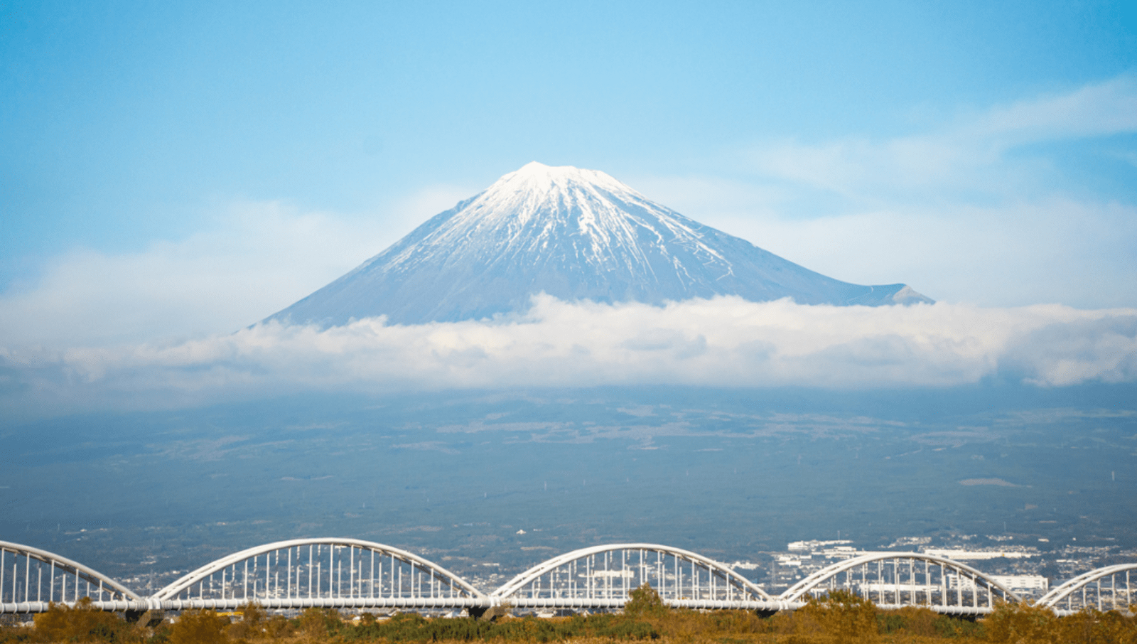 View of bridge and Mount Fuji surrounded by clouds