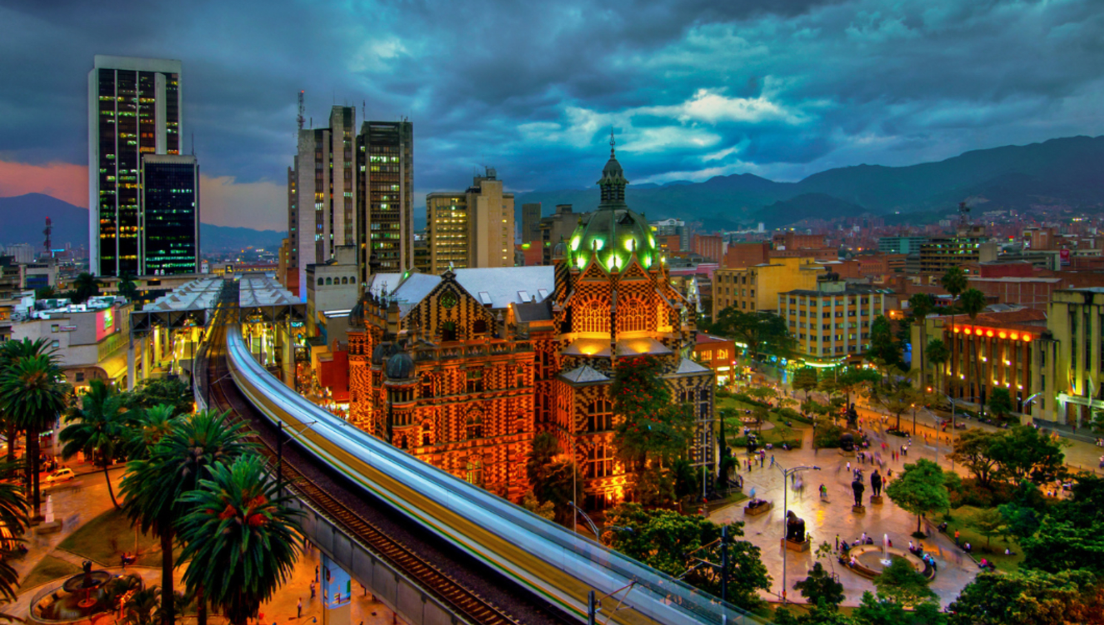 Train on tracks above the city going through medellin colombia at night