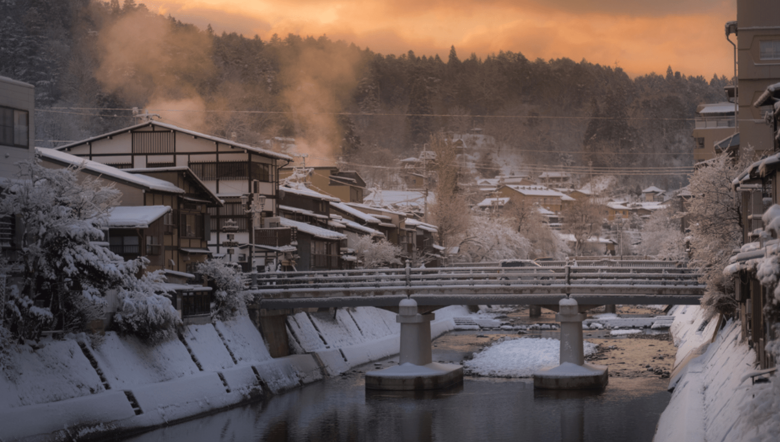 Bridge over a river in a town covered in snow at sunrise