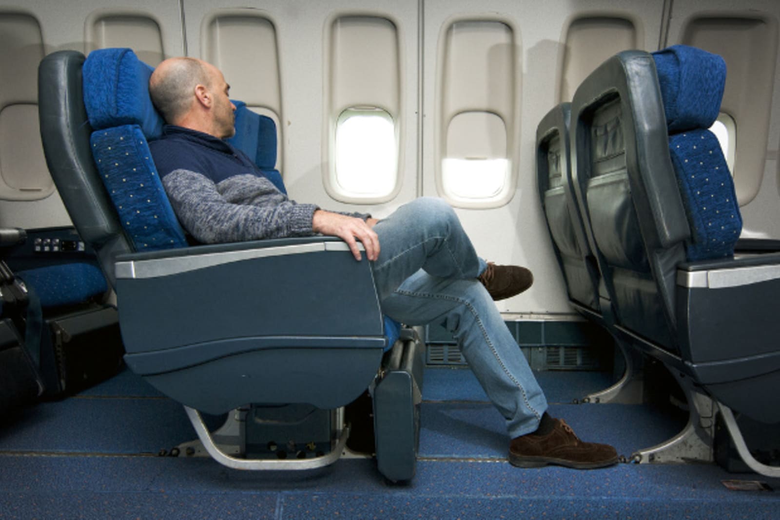 Person sitting in an Airline seat showing how spacious the leg room 