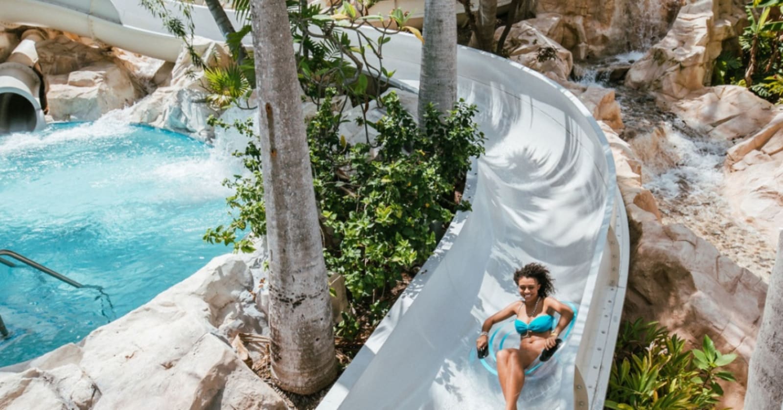 Teenage girl on a white water slide, flying past rocks and trees