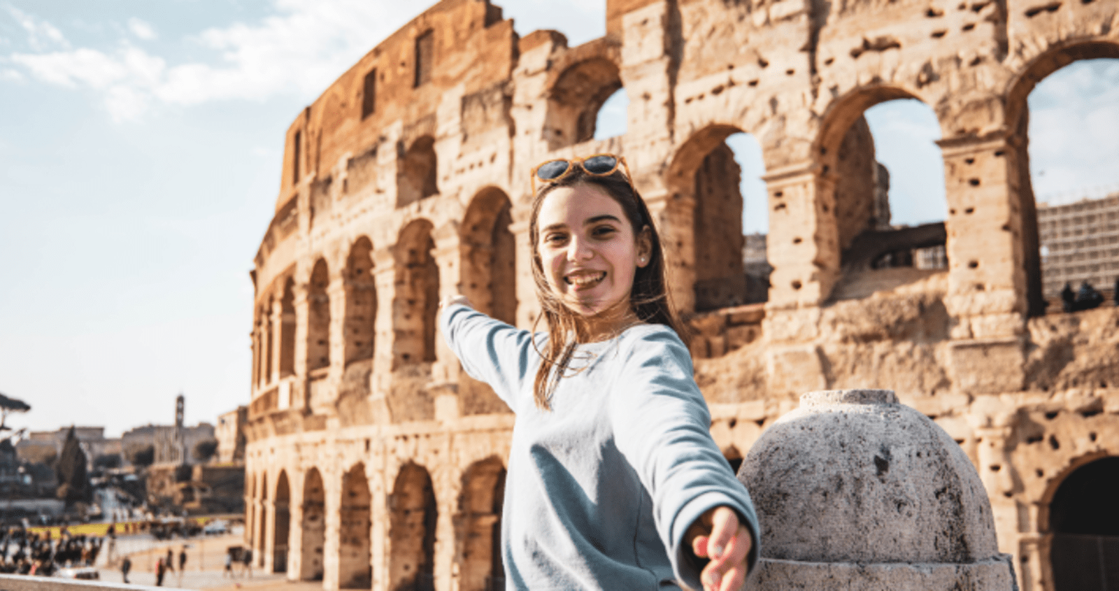 Teenage girl standing in front of the Colosseum in Rome