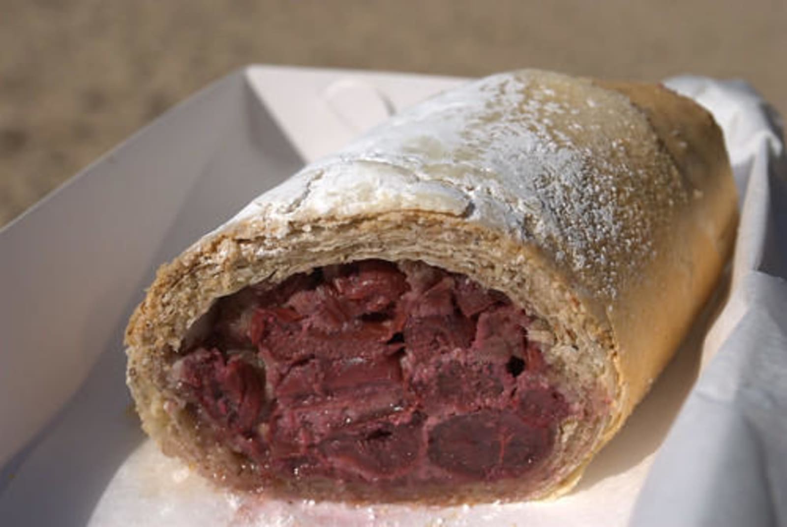 Cherry strudel - a deep maroon filling with crusty pastry dusted with sugar