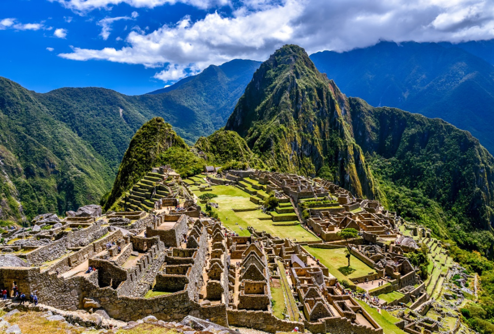 The sun shines on the mountainous stony ruins of Machu Picchu