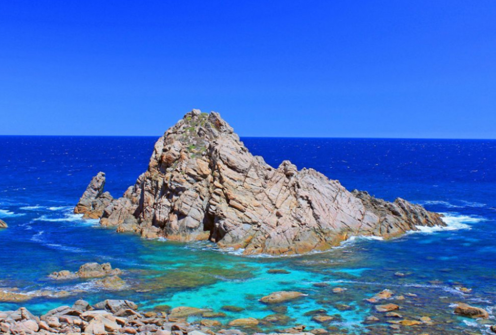 Blue seas surround a rocky island at Cape Naturaliste, Western Australia