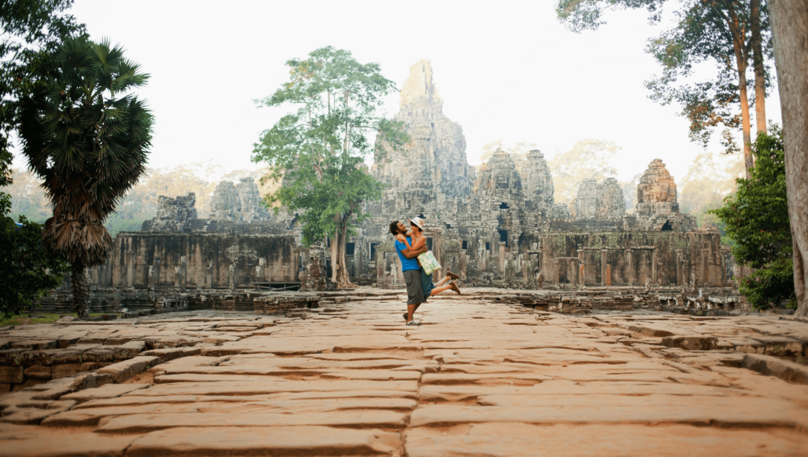 couple hugs in front of Angkor Wat in Cambodia 