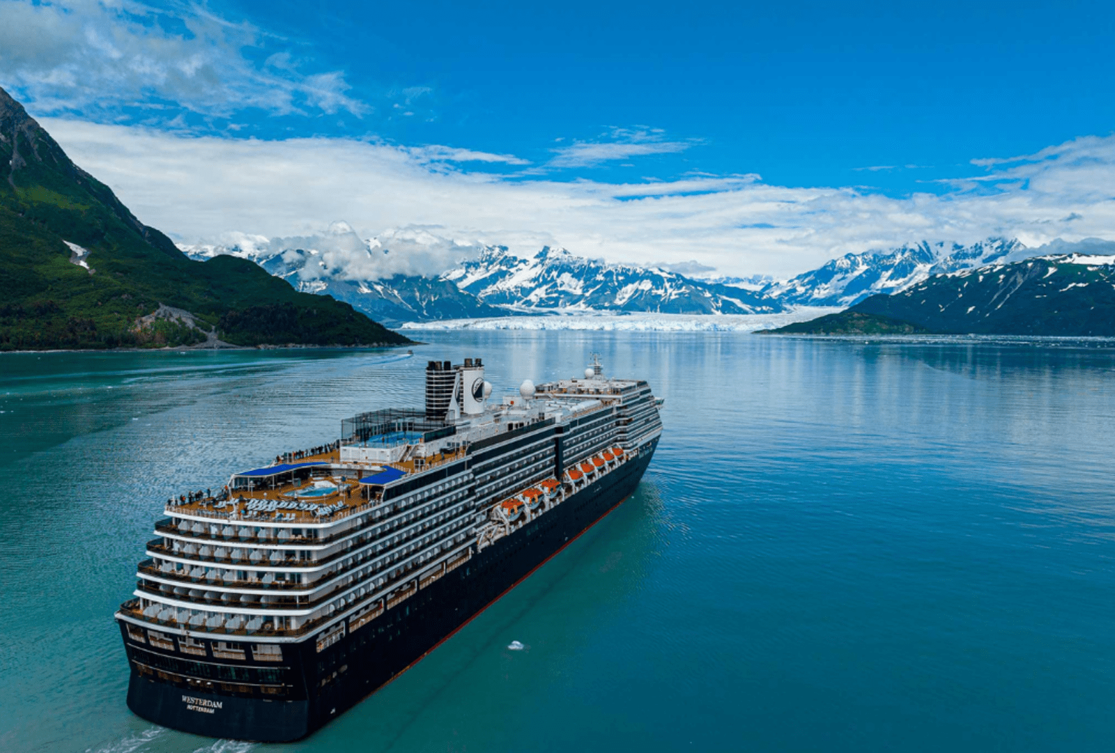 A cruise ship sails along a channel where mountains and glaciers meet the sea
