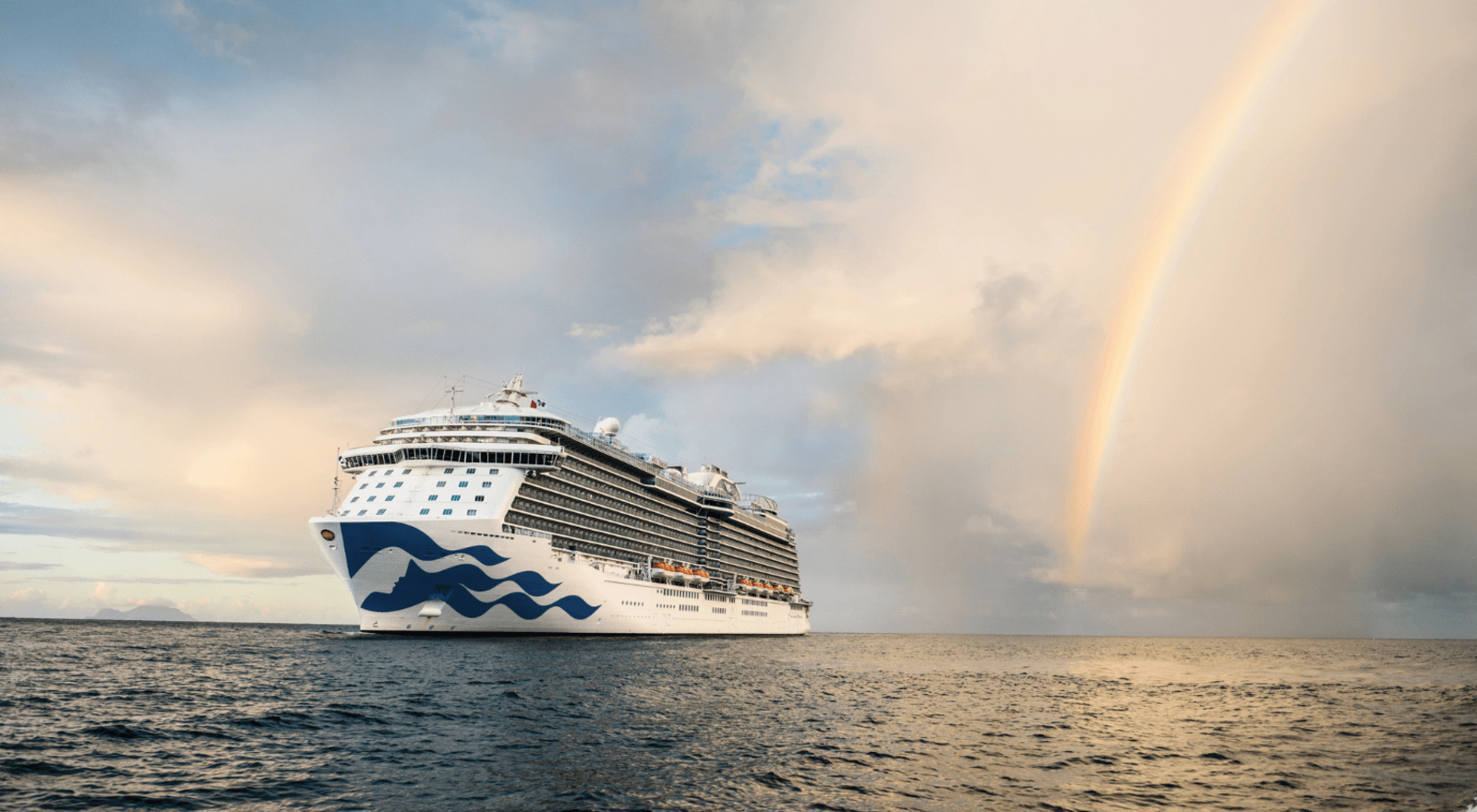 A cruise ship sails beside a rainbow