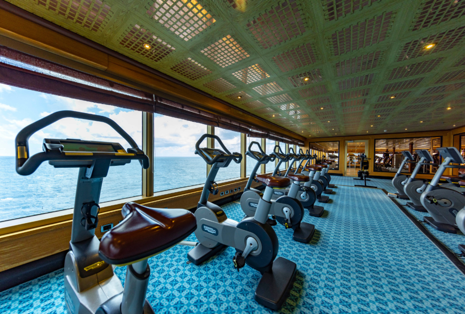 A line of exercise bikes looking out over the sea on a cruise ship