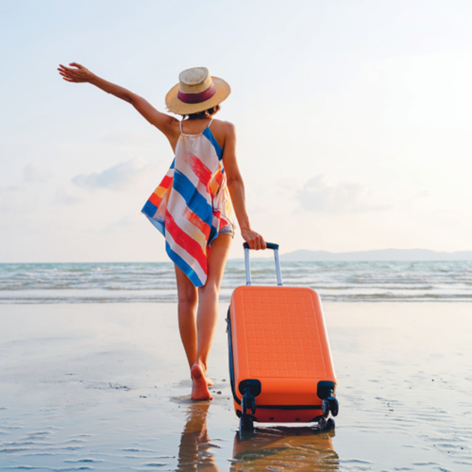 Lady on beach with suitcase