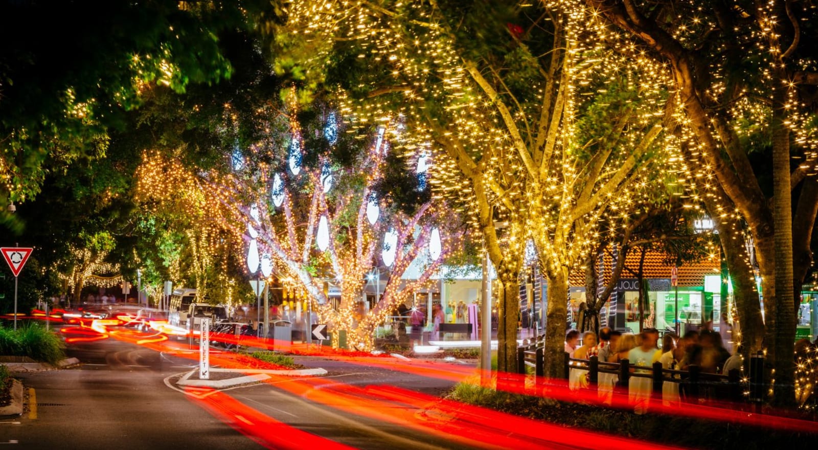 noosa street at night with trees covered in lights 