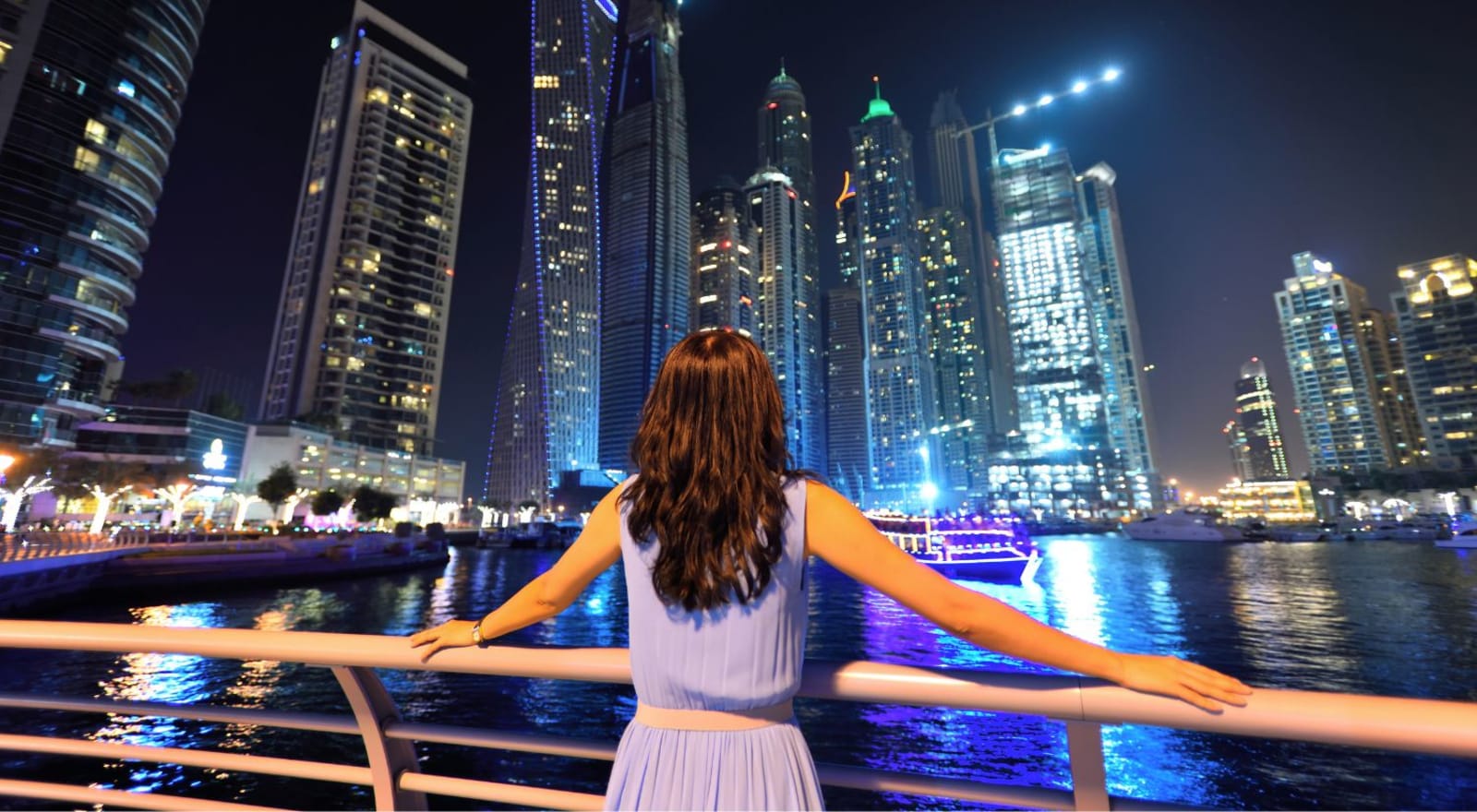 lady standing against railing looking at city of dubai