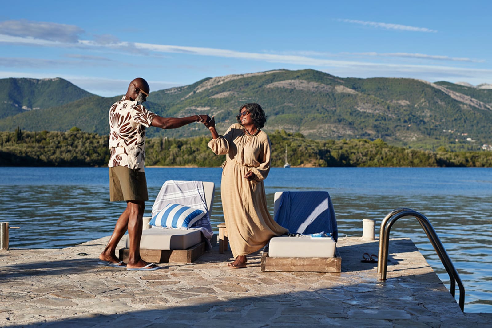 A senior couple dancing on a dock on vacation