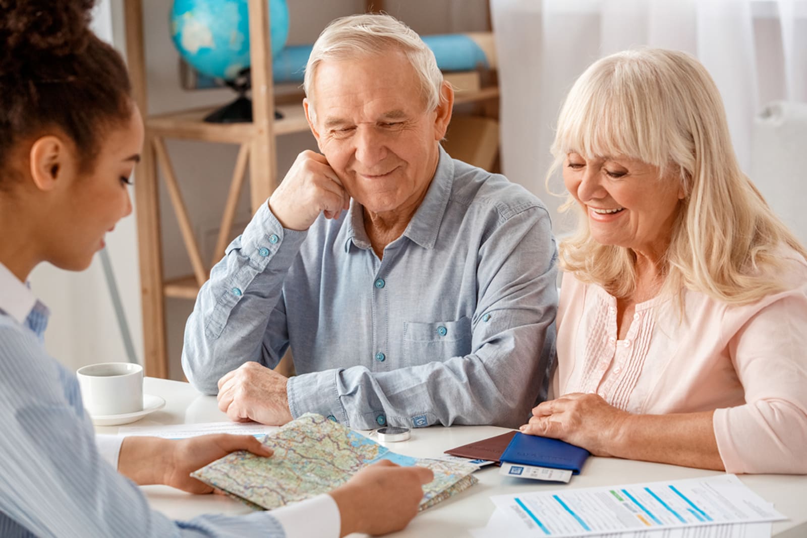 A senior couple chatting with a travel consultant about insurance