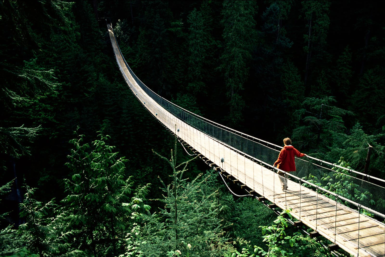 A person walking across Capilano Suspension Bridge in North Vancouver