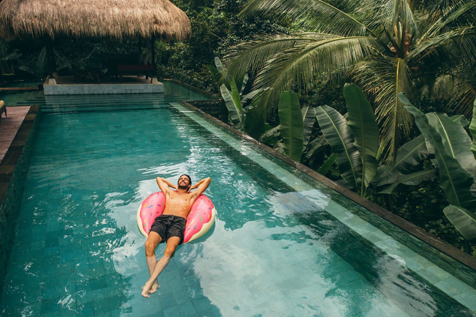 Man floating on a doughnut-shaped inner tube in a pool at a Mexico resort