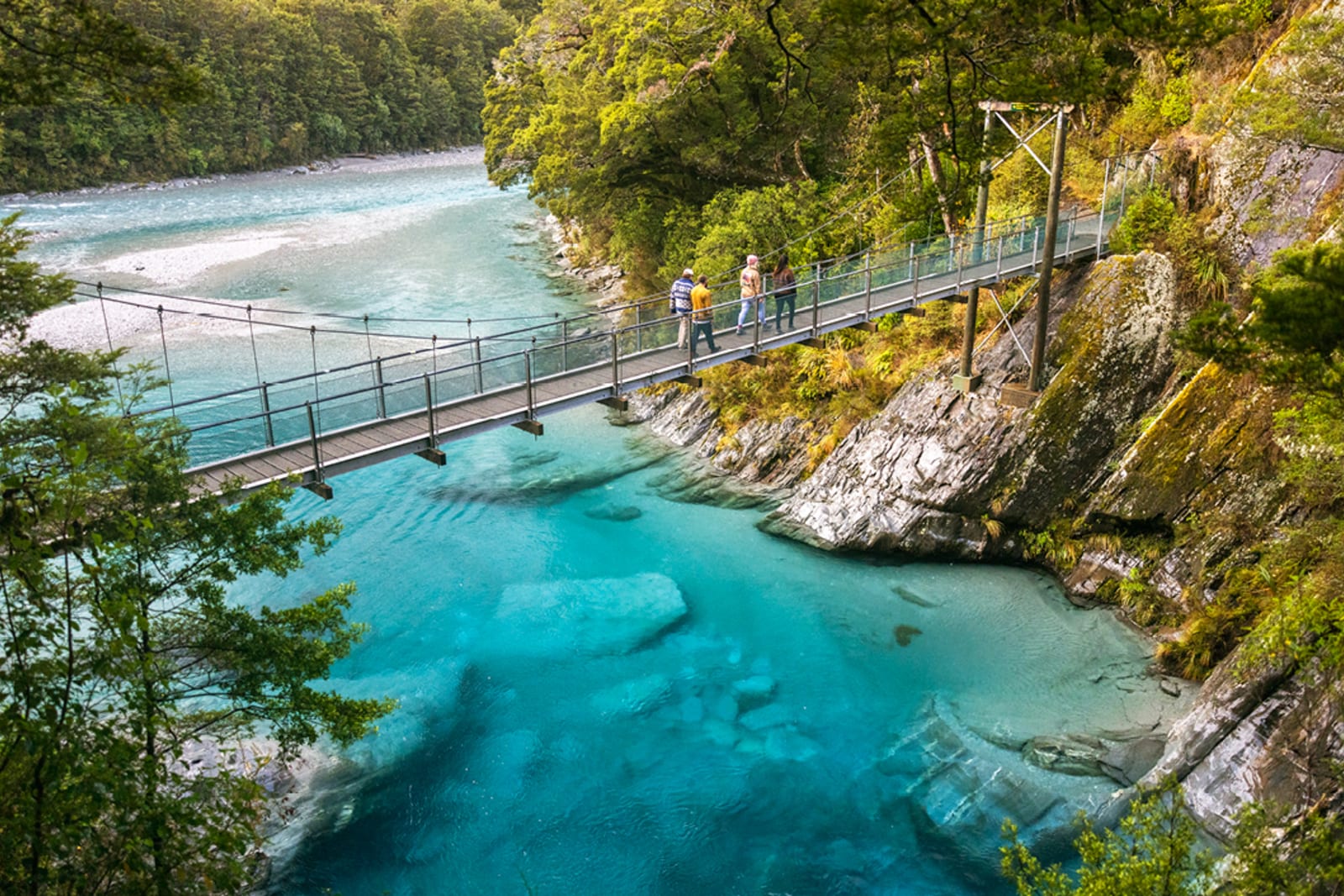 A bridge over blue waters at the Haast UNESCO World Heritage Area