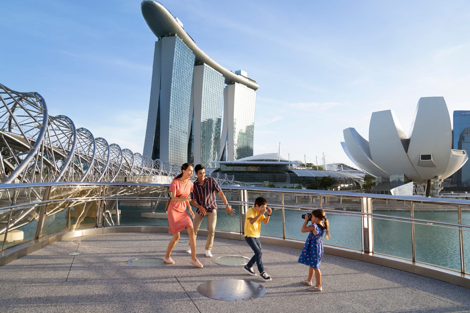 A family in the front of Marina Bay Sands and Helix Bridge in the background 