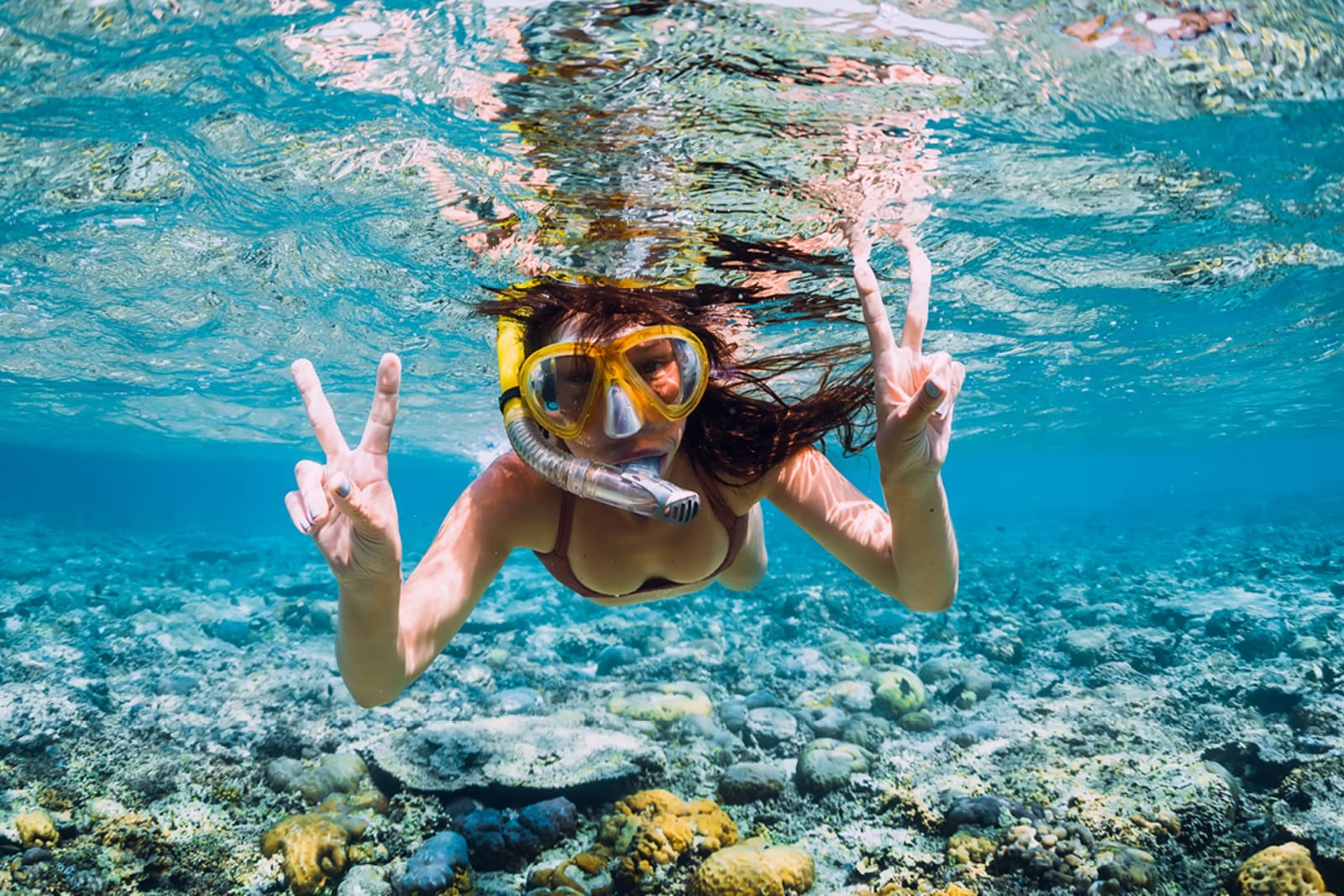 A woman snorkelling above a coral reef in the Dominican Republic