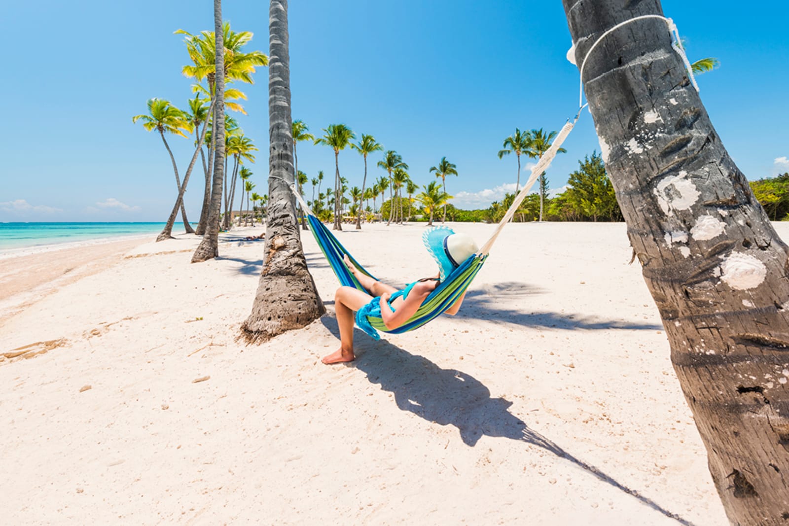 A traveller relaxing in a hammock on a beach in Punta Cana, Dominican Republic