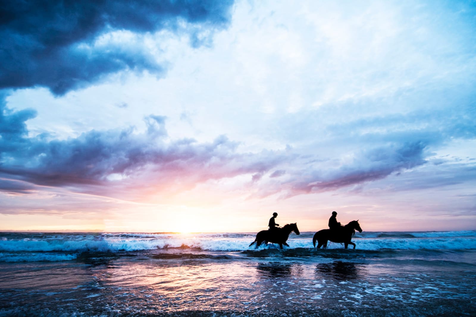 Couple horseback riding on a beach in Punta Cana at sunset