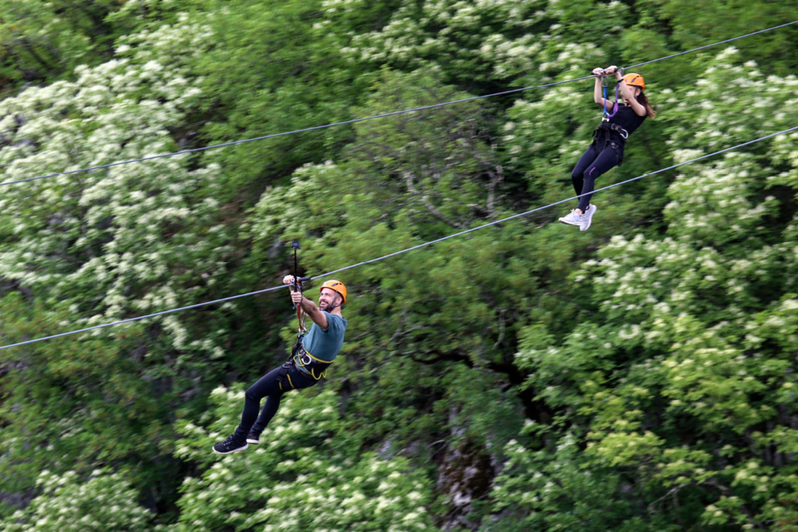 A couple ziplining above the trees at a natural park in Punta Cana