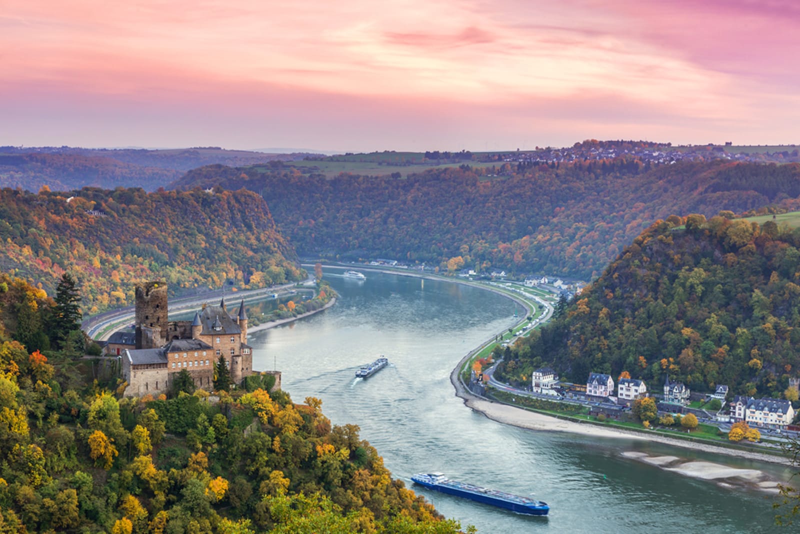 River cruises navigating through the Rhine Gorge at sunset