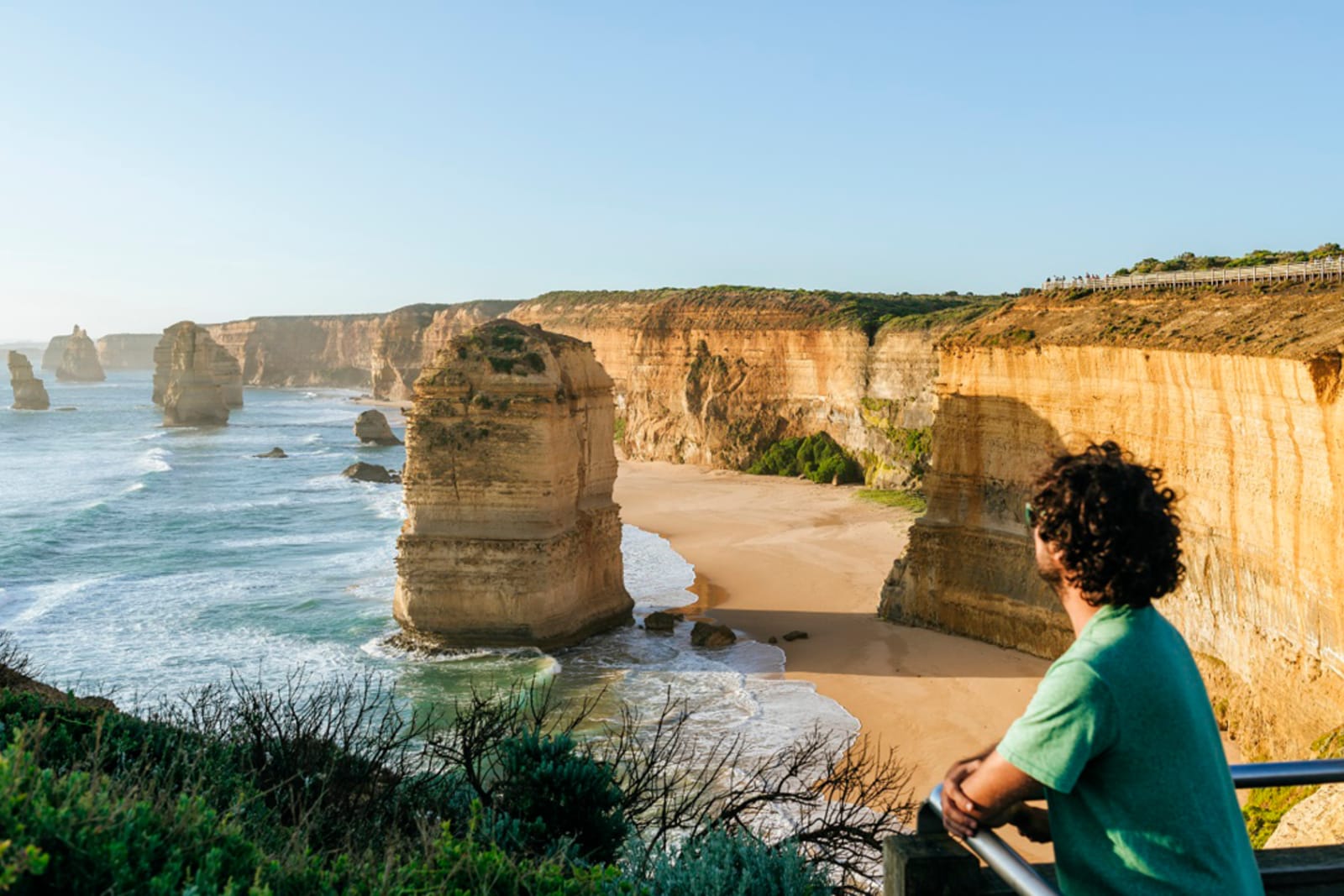 A traveller overlooking the Twelve Apostles rock formation during a pit stop on the Great Ocean Road