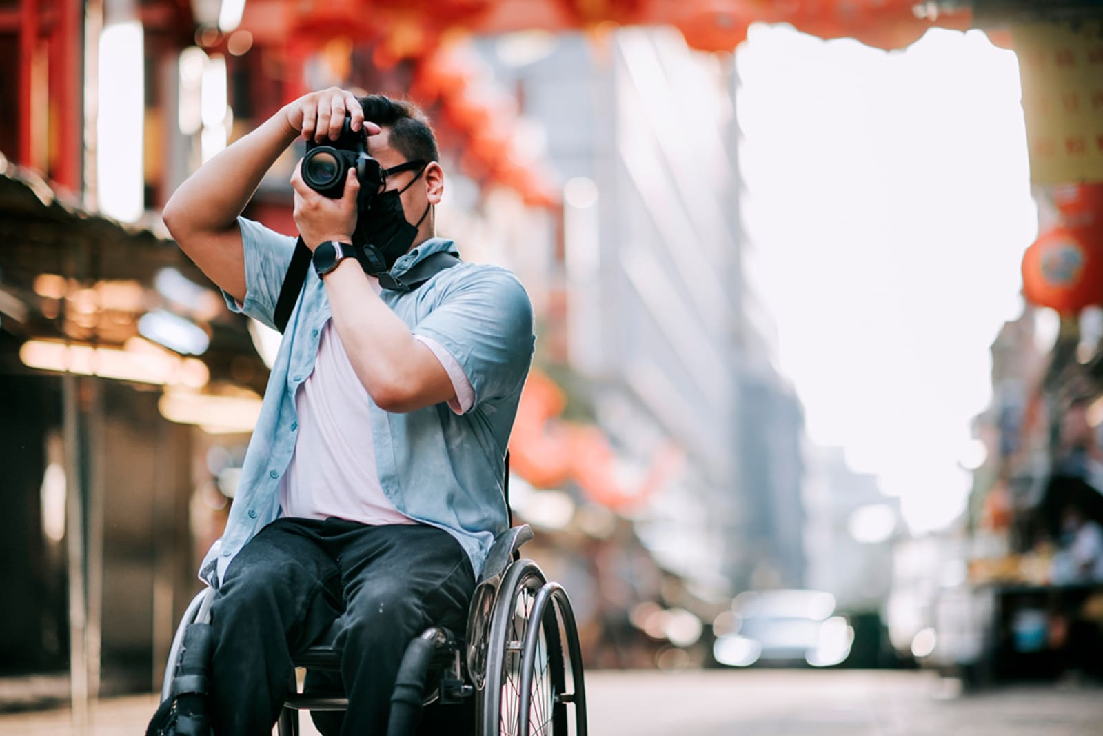 A wheelchair user taking pictures of a city in Asia
