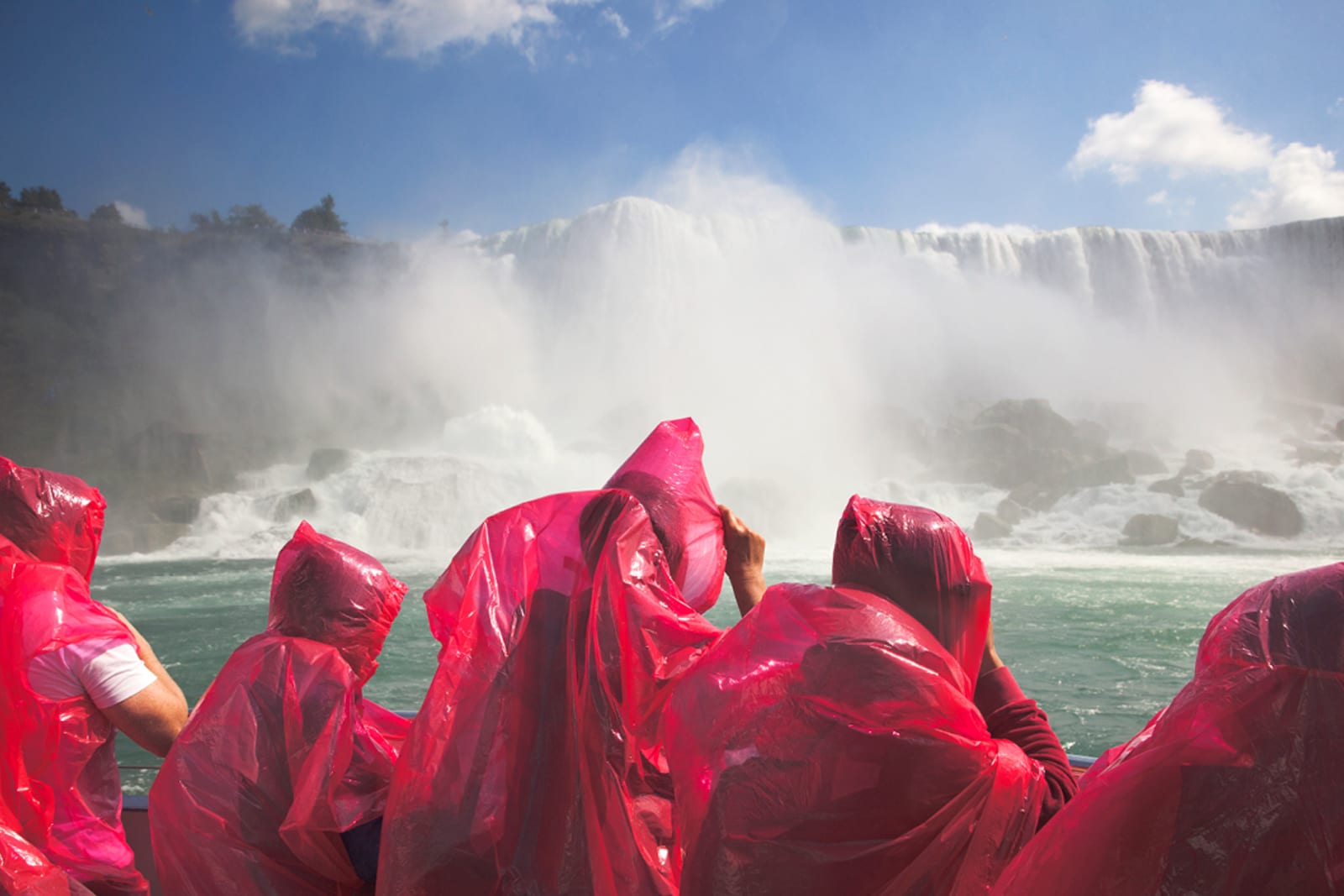 Group of people wearing ponchos while getting up close to Niagara Falls