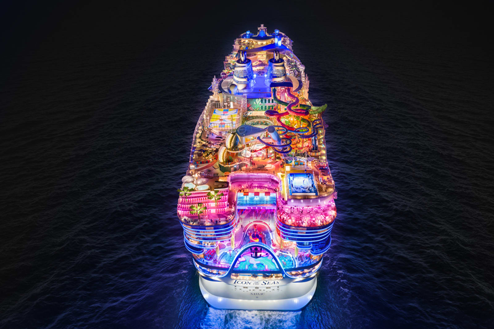 A brightly lit cruise ship sailing at night