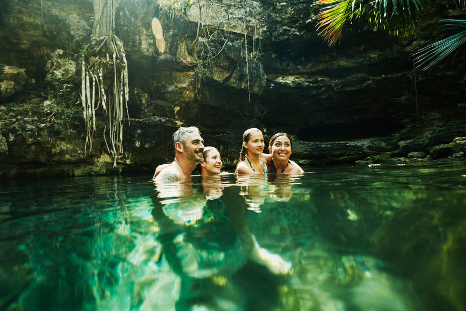 A family of four swimming in a cenote
