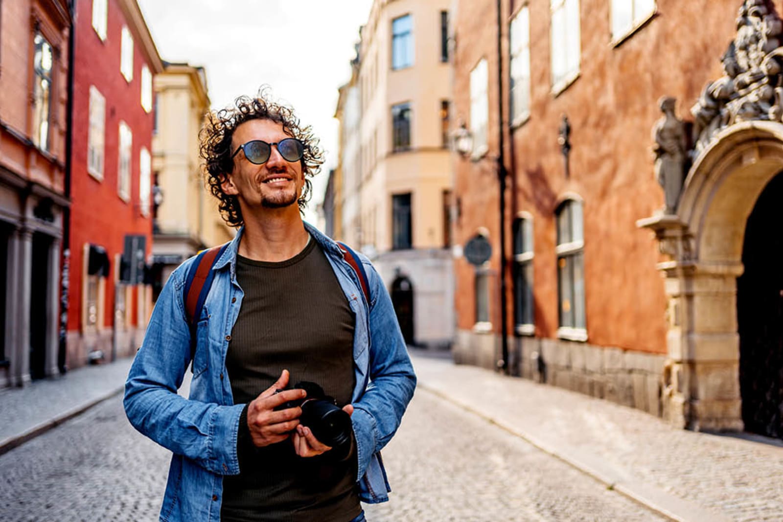 Smiling traveller walking down cobbled street