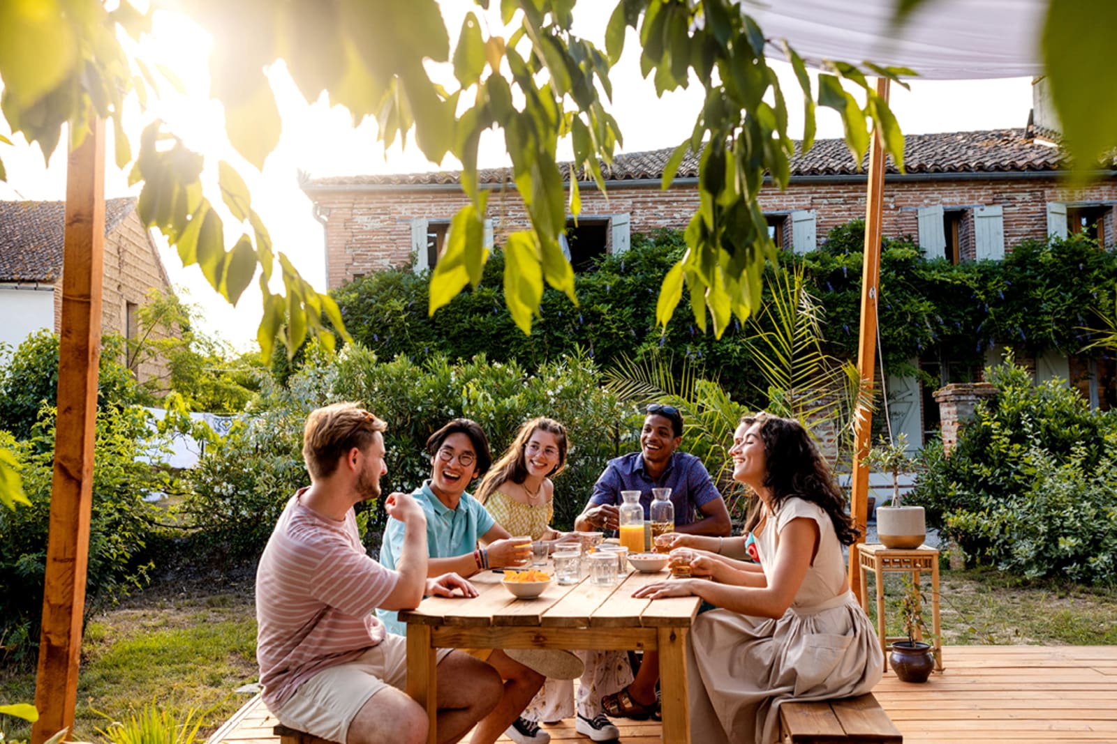 A group of friends embracing slow travel by having a long, leisurely dinner on a patio