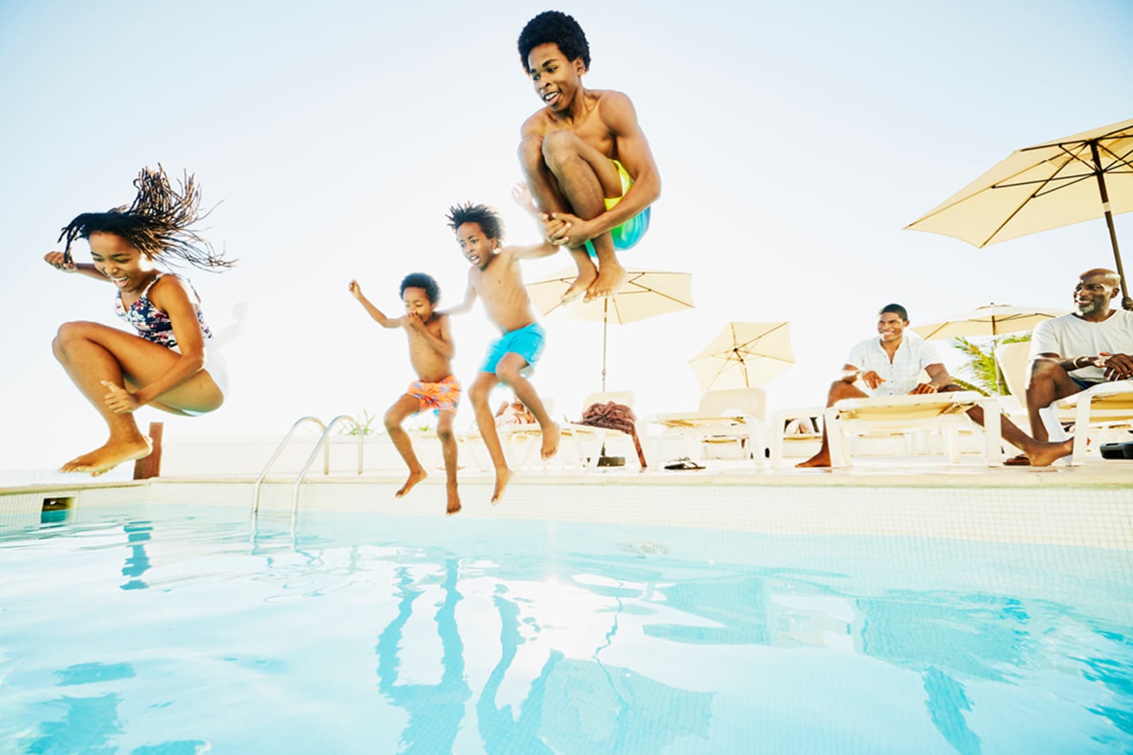 Kids jumping into a pool at an all-inclusive resort