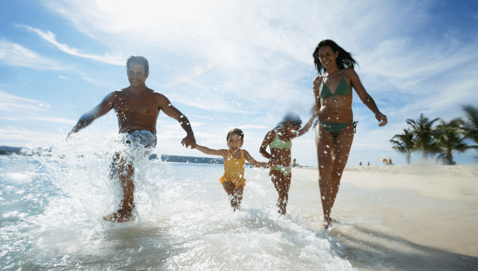 Two adults and two children having fun in the water at the beach