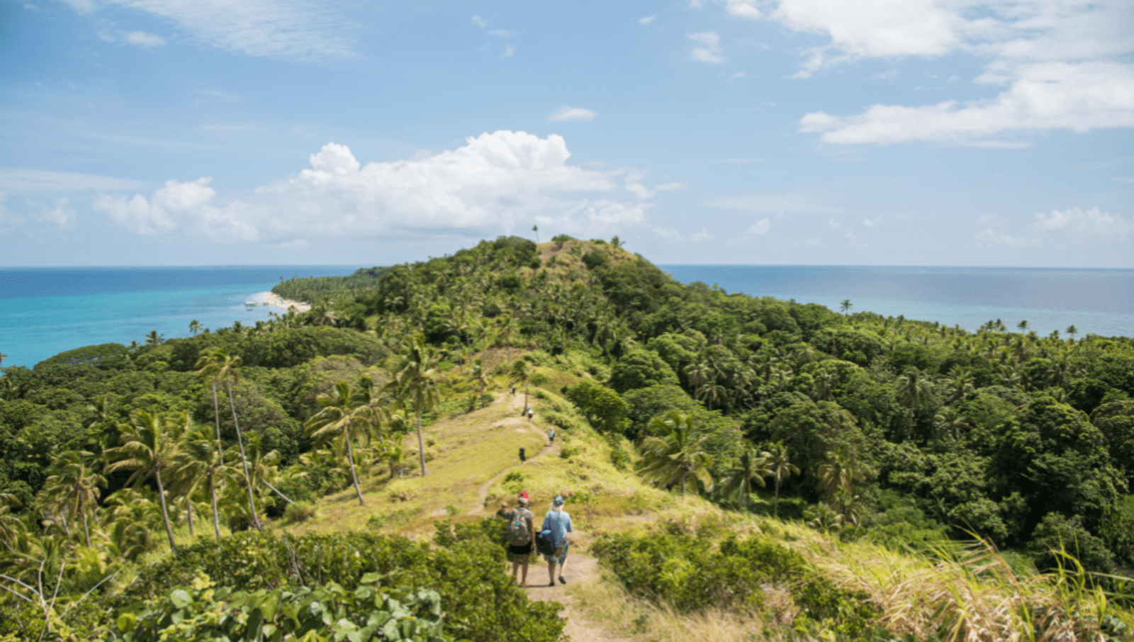 People hiking on high headland in Fiji 